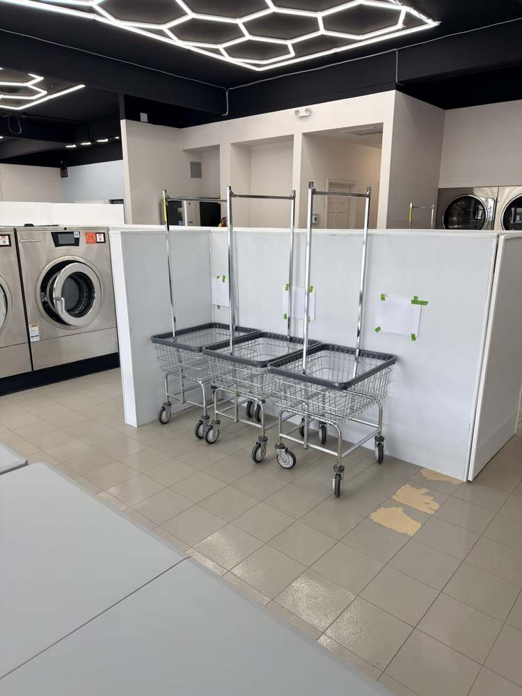 Rolling laundry carts under the geometric lights at Crew’s
