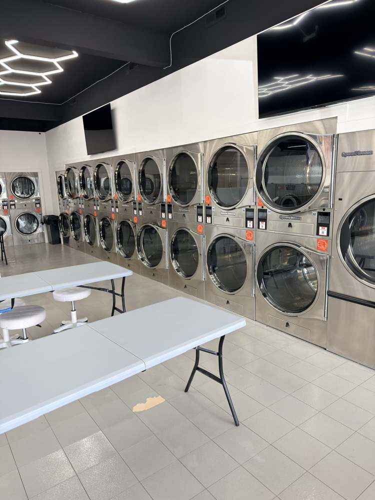 Speed Queen dryer wall with folding tables at Crew’s